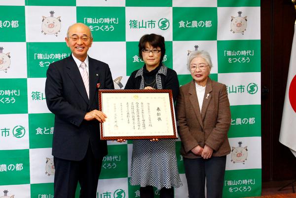 にしき北愛育班班長の細見 ますみさんらが市長と一緒に額に入った表彰状を持って記念撮影している写真